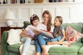 Two little girls are reading a book with their mother Royalty Free Stock Photo