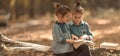 Two little girls reading books in the woods Royalty Free Stock Photo