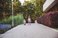 Two little girls rides on rollers and runbike in summer park. Children wearing protection pads and safety helmet for Royalty Free Stock Photo