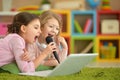 two little girls singing karaoke on laptop together Royalty Free Stock Photo