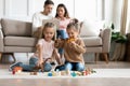 Two little girls sisters playing with toys while parents resting Royalty Free Stock Photo