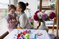 Two little girls, the older one kissing her sister while playing with colored threads Royalty Free Stock Photo