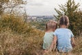 Two little sisters are sitting on a hill above the city Royalty Free Stock Photo