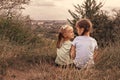 Two little sisters are sitting on a hill above the city Royalty Free Stock Photo