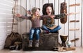 Two little girls sitting on wooden chest with hands up Royalty Free Stock Photo