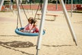 Two little girls are swinging on a swing at the playground Royalty Free Stock Photo