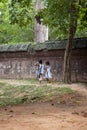 Two little girls walking along a stone wall