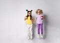 Little kids in sunglasses, colorful casual clothes. Girls holding hands and cocktail bottles, jumping up, posing isolated on white