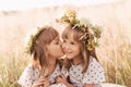 Two little happy identical twin girls playing together in nature in summer. Girls friendship and youth concept. Active children`s