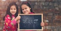 Two little Indian Rural girls holding slate board