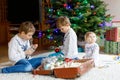 Two little kid boys and adorable baby girl decorating Christmas tree with old vintage toys and balls. Family Royalty Free Stock Photo