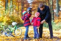 Two little kid boys and father with bicycles in autumn park Royalty Free Stock Photo