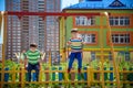 Two little kid boys having fun with swing on outdoor playground. Children, best friends and siblings swinging on warm sunny spring Royalty Free Stock Photo