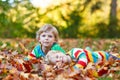 Two little kid boys laying in autumn leaves in colorful clothing Royalty Free Stock Photo