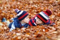 Two little kid boys lying in autumn leaves, in park. Royalty Free Stock Photo