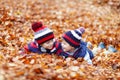 Two little kid boys lying in autumn leaves, in park. Royalty Free Stock Photo