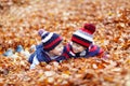 Two little kid boys lying in autumn leaves, in Royalty Free Stock Photo