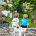 Two little kid boys sitting together on stone bridge Royalty Free Stock Photo