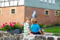 Two little kid boys sitting together on stone bridge Royalty Free Stock Photo