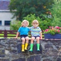 Two little kid boys sitting together on stone bridge Royalty Free Stock Photo