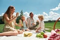 Two little kids blowing soap bubbles while spending time with their parents, family having picnic in nature on a summer Royalty Free Stock Photo