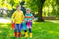 Two little kids boys, cute siblings with lots of colorful rain boots. Children in different rubber boots and jackets Royalty Free Stock Photo