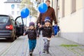 Two little kids boys and dad playing with blue air balloons outdoors. Happy twins and toddler brothers and father, young