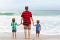 Two little kids boys and father on the beach of ocean Royalty Free Stock Photo