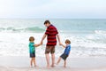 Two little kids boys and father on the beach of ocean Royalty Free Stock Photo