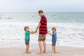 Two little kids boys and father on the beach of ocean Royalty Free Stock Photo