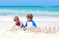Two little kids boys having fun with building a sand castle on tropical beach of Playa del Carmen, Mexico. children Royalty Free Stock Photo