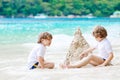 Two kid boys building sand castle on tropical beach Royalty Free Stock Photo