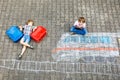 Two little kids boys having fun with train picture drawing with colorful chalks on ground Royalty Free Stock Photo
