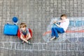 Two little kids boys having fun with train picture drawing with colorful chalks on ground Royalty Free Stock Photo
