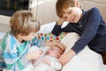 Two little kids boys playing with newborn baby sister girl Royalty Free Stock Photo