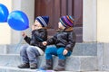 Two little kids boys playing with blue air balloons outdoors. Happy twins and toddler brothers smiling and laughing Royalty Free Stock Photo