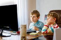 Two little kids boys playing computer games on desktop pc. Modern addict activity for children. Siblings and friends Royalty Free Stock Photo