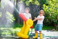 Two little kids boys playing with a garden hose water sprinkler Royalty Free Stock Photo