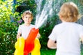 Two little kids boys playing with a garden hose water sprinkler Royalty Free Stock Photo