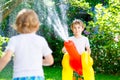 Two little kids boys playing with a garden hose water sprinkler Royalty Free Stock Photo