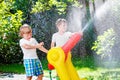 Two little kids boys playing with a garden hose water sprinkler Royalty Free Stock Photo