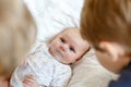 Two little kids boys playing with newborn baby sister girl