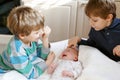Two little kids boys playing with newborn baby sister girl Royalty Free Stock Photo