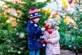 Two little kids eating crystalized apple on Christmas market Royalty Free Stock Photo