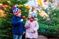 Two little kids eating crystalized apple on Christmas market Royalty Free Stock Photo