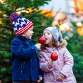 Two little kids eating crystalized apple on Christmas market Royalty Free Stock Photo