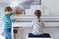 Two little kids girl and boy playing piano in living room or music school Royalty Free Stock Photo