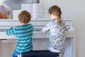 Two little kids girl and boy playing piano in living room or music school Royalty Free Stock Photo