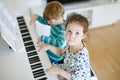 Two little kids girl and boy playing piano in living room or music school Royalty Free Stock Photo