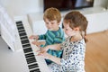 Two little kids girl and boy playing piano in living room or music school Royalty Free Stock Photo